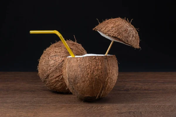 Siyah arka planda pipetli hindistan cevizi kokteyli..