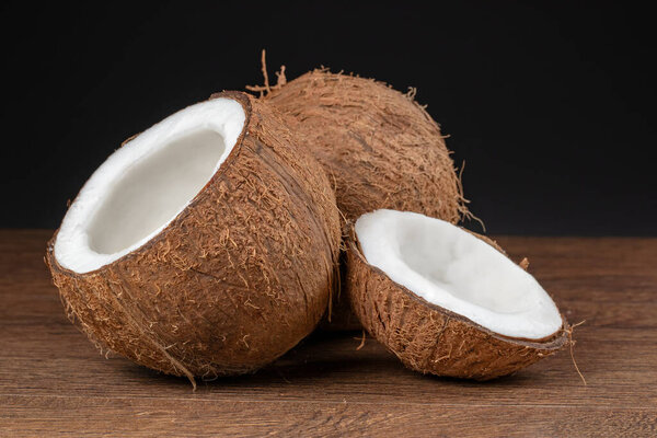 Coconut with half on dark background.