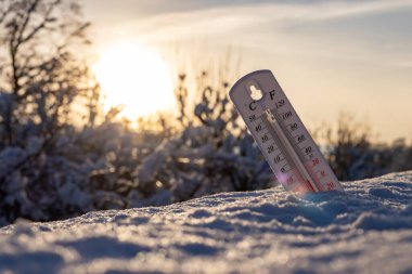 Kardaki termometre, Celsius veya Fareheit 'te düşük sıcaklık gösteriyor. Gün batımında.