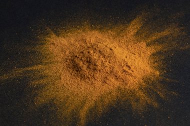 Koyu arkaplanda zerdeçal tozu, Hint baharatı, vejetaryen mutfak konsepti için sağlıklı baharat bileşeni..