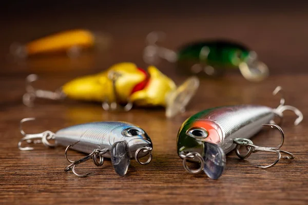 Colorful fishing lures, wobbler, spinner, on wood desk different fishing baits