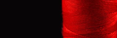 Siyah arkaplanda kırmızı iplik makarası.