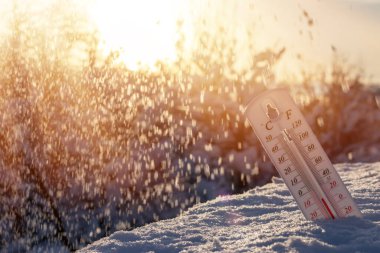 Kardaki termometre, Celsius veya Fareheit 'te düşük sıcaklık gösteriyor. Gün batımında.