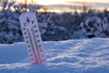 Kardaki termometre, Celsius veya Fareheit 'te düşük sıcaklık gösteriyor. Gün batımında.