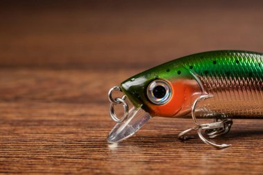 Tahta arka planda balık tutmak için oltaya yem takmak..