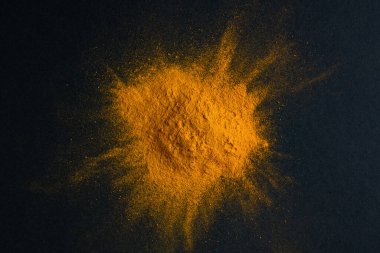 Koyu arkaplanda zerdeçal tozu, Hint baharatı, vejetaryen mutfak konsepti için sağlıklı baharat bileşeni..