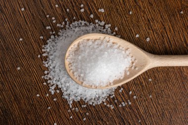 Ahşap zemin üzerinde tuz bulunan tahta kaşık..