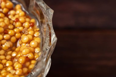 Ahşap arka planda cam kasede Fransız hardal sosu..