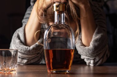 Kadın alkolizmi işte. Kadın kadın evde oturup alkol şişesi içiyor üzgün alkolizm belirtileri ve semptomlar rehabilitasyon sorunları ve iyileşme sorunları.