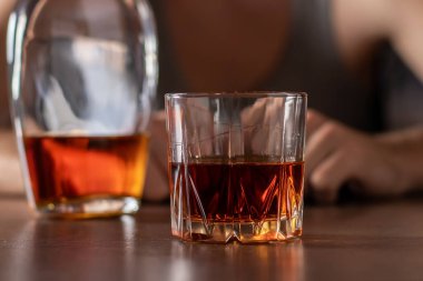 Alkolizm konsepti. Genç adam çok fazla alkol alıyor. Bir bardak viskiyle tişört giymiş alkolik..
