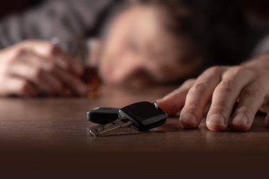 Alkolizm, alkol bağımlılığı ve insan konsepti. Bir bardak viskiyle masada yatan ya da uyuyan erkek alkolik..