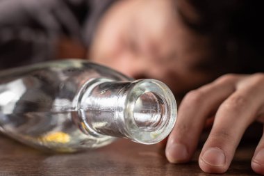 sarhoş adam neredeyse boş şişe alkol ile sleeping.