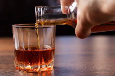 Alkolizm konsepti. Genç adam çok fazla alkol alıyor. Alkolik bardağa alkol dolduruyor..