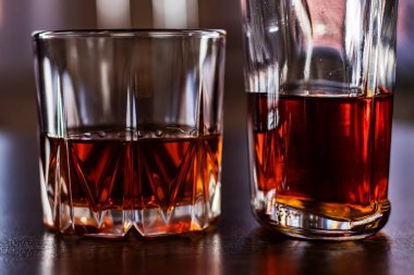 Viski bardağı ve şişe ahşap masada..