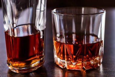 Viski bardağı ve şişe ahşap masada..