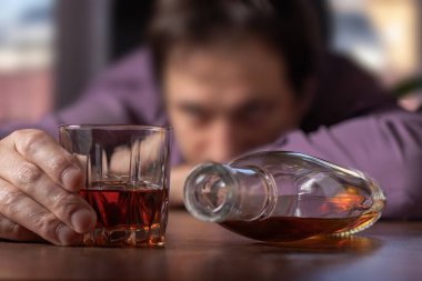Alkolizm konsepti. İş adamı mesai sonrası alkol içiyor..
