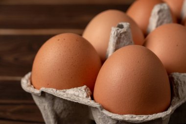 Mutlu Paskalyalar. Paskalya yumurtaları. Tavuklu kahverengi yumurtalar. Masanın üstüne yakın çekim. Bir karton taze kahverengi yumurta. Yumurta kutusundaki organik tavuk yumurtaları..