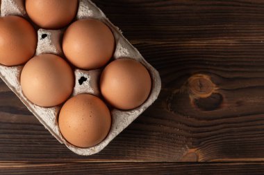 Mutlu Paskalyalar. Paskalya yumurtaları. Tavuklu kahverengi yumurtalar. Masanın üstüne yakın çekim. Bir karton taze kahverengi yumurta. Yumurta kutusundaki organik tavuk yumurtaları..