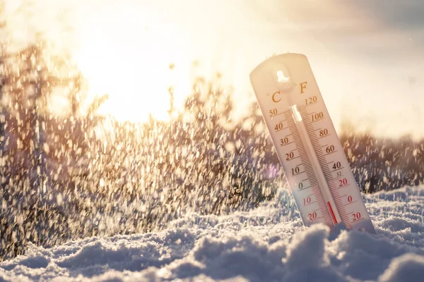 Kardaki termometre, Celsius veya Fareheit 'te düşük sıcaklık gösteriyor. Gün batımında.