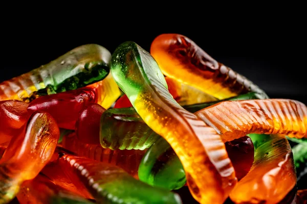 Haufen Saftige Bunte Gelee Würmer Süßigkeiten Gummibärchen Schlangen Auf Schwarz — Stockfoto