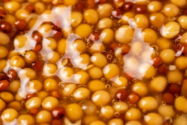 Fransız hardal tohumlarının tüm arka planında sıvı var. Kapat..