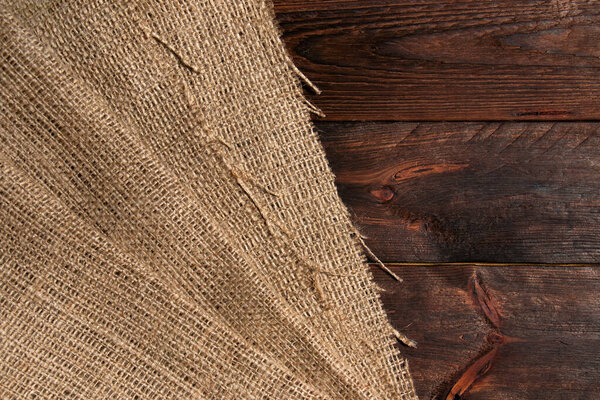 Wood table with old burlap tablecloth texture.