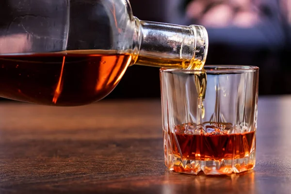 Cam, koyu renk arka plan, seçici odak viski Pour.