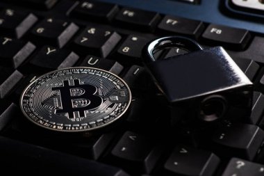 Bitcoin güvenlik konsepti. Bilgisayar klavyesinde asma kilit olan gümüş para