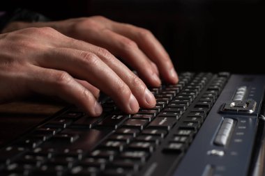 Eller bilgisayarda çalışır, klavye çalar, modern ofiste proje planlar, kapat. Yönetici müdürü, şirket adamı iş raporunu masasında düzeltiyor.