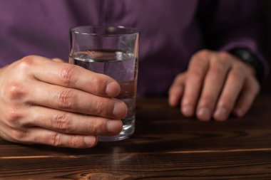 Bir bardak sudan içen adam. Sağlık hizmeti konsepti fotoğrafı, yaşam tarzı, yakın plan..