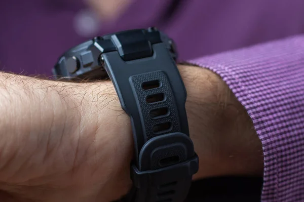 Close up shot of a man hand that uses a smart watch to view incoming messages and calls to a mobile phone that lies in the pocket of his jacket, the gadget simplifies his life.