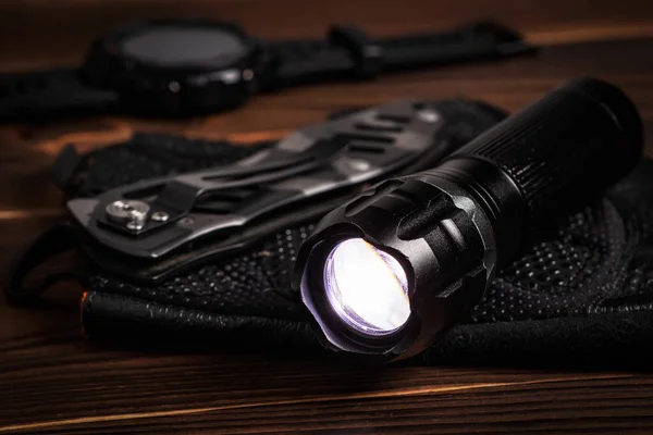 Everyday carry EDC items for men in black color - included flashlight, watch and knife. Survival set. Minimal concept