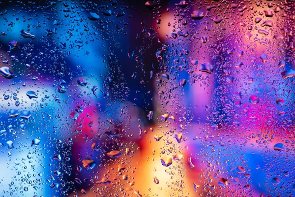 Terli camda bir damla yoğuşma var. Arka planda soğuk sisli cam gece ışıkları.