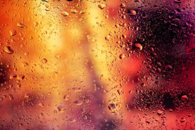 Terli camda bir damla yoğuşma var. Arka planda soğuk sisli cam gece ışıkları.