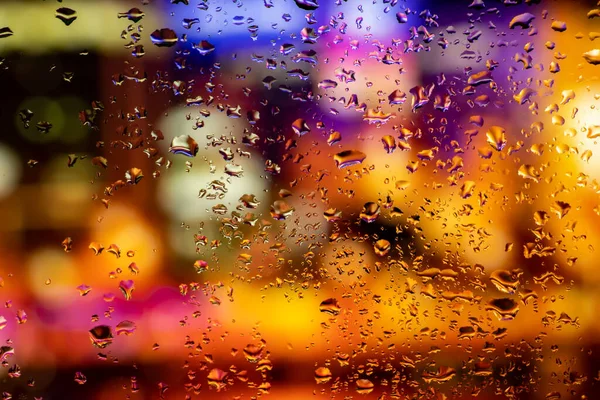 Terli camda bir damla yoğuşma var. Arka planda soğuk sisli cam gece ışıkları.