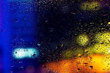 Pencere camında su damlaları ve buharlaşma. Soyut arkaplan niglt Işık.