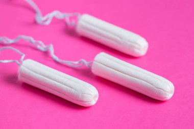 Tıbbi kadın tamponu pembe arka planda kapanıyor. Kadınlar için hijyenik beyaz tampon. Pamuklu çubuk. Regl, korunma aracı. Kırmızı arkaplanda tamponlar.