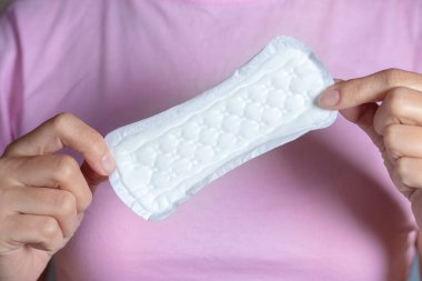 Pembe arka planda el temizliği pedi tutan kız..