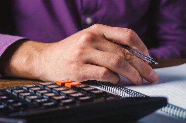 Finansal veri analizi. Ofisteki hesap makinesine güvenen bir iş adamının el yazısının yakın plan fotoğrafı.