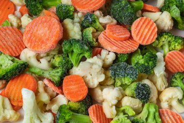 Beyaz arka planda bir yığın donmuş sebze karışımı. İzole edilmiş,