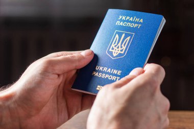 Elinde kimlik çipi olan yeni Ukrayna mavi biyometrik pasaportu.