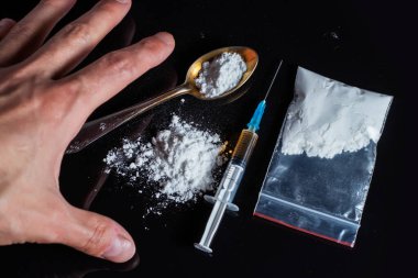 Uyuşturucu karşıtı kavram. Uyuşturucu bağımlısı şırıngadaki ilaçtan bir doz daha alıyor. Adam bağımlı, erkek uyuşturucu bağımlısı, şırınga