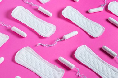 Tamponlar, pembe arka planda kadın hijyenik pedleri. Kritik günlerde hijyen bakımı. Adet döngüsü. Kadın sağlığıyla ilgilenmek. Aylık koruma.