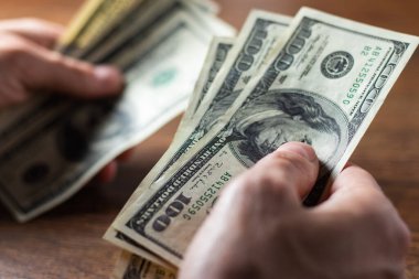 Erkek eli kapalı, bize dolar sayıyor. Finansal iş kavramı