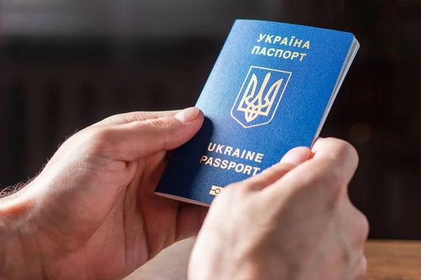 Elinde kimlik çipi olan yeni Ukrayna mavi biyometrik pasaportu.