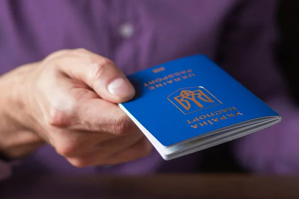 Elinde kimlik çipi olan yeni Ukrayna mavi biyometrik pasaportu.
