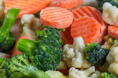 Beyaz arka planda bir yığın donmuş sebze karışımı. İzole edilmiş