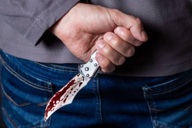 Arkasında kanlı bıçak taşıyan bir suçlu..