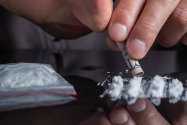 Konsept uyuşturucu bağımlılığı, uyuşturucu bağımlılığı, uyuşturucu kullanan adam, kokain çeken adam, yakın çekim..