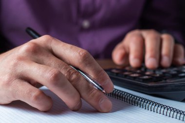 Finansal veri analizi. Ofisteki hesap makinesine güvenen bir iş adamının el yazısının yakın plan fotoğrafı.